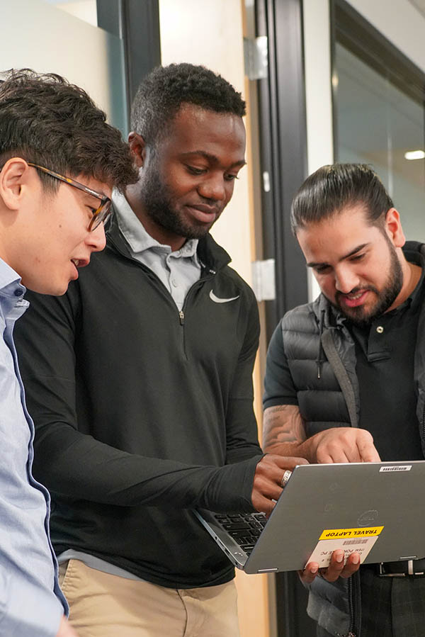 photo of three researcher working outdoors on a tablet